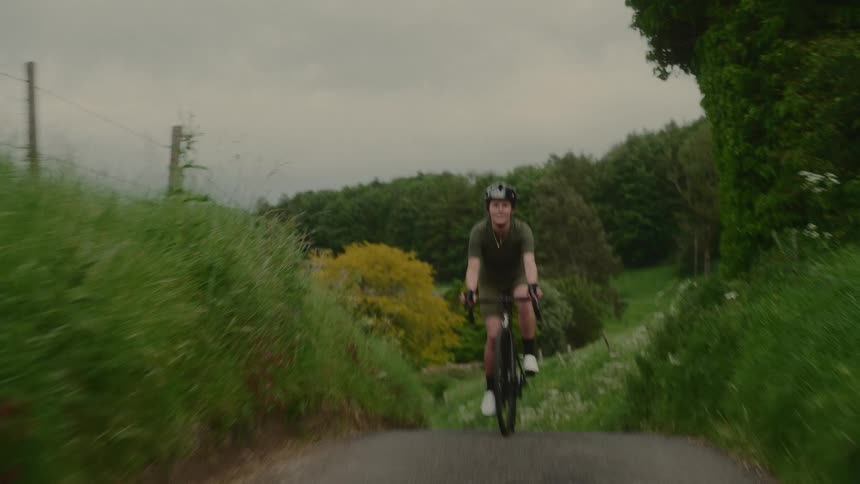 Female cyclist riding through a countryside trail environment