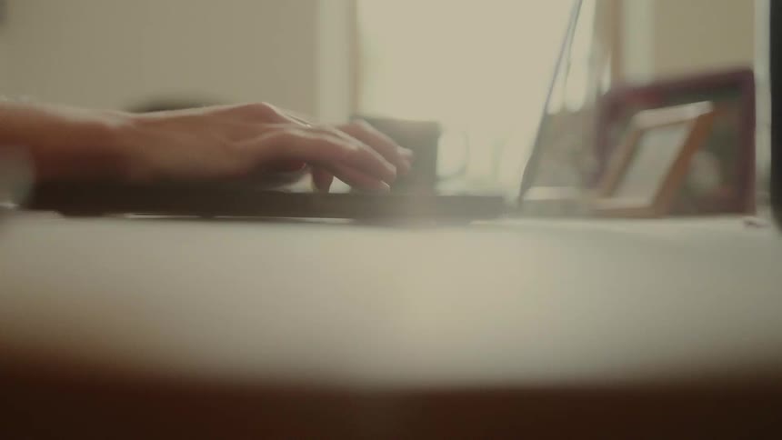 The woman is typing fast on the laptop