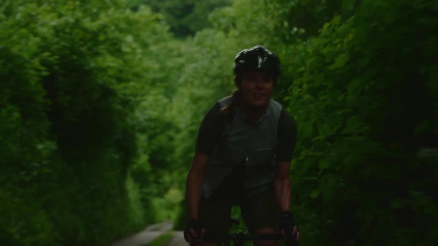 Female cyclist riding along a forest trail