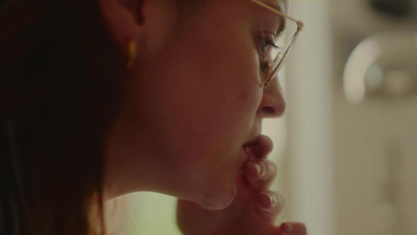 A woman has her hand to her chin thinking