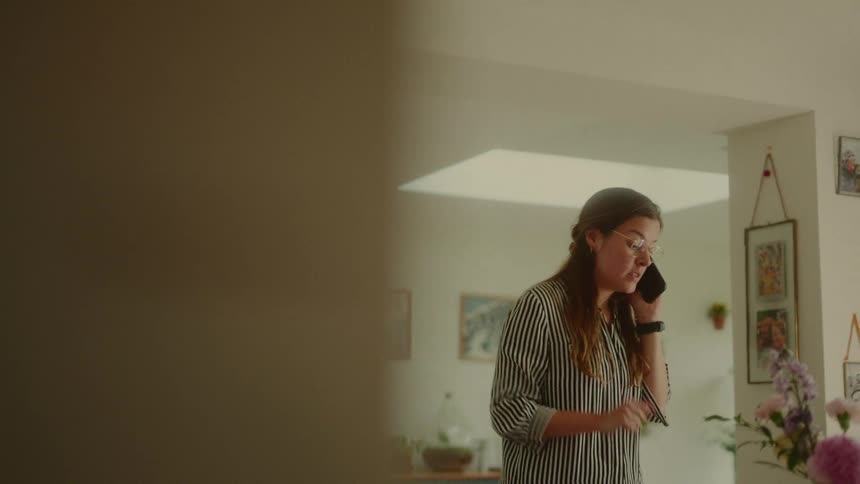 Woman sitting at desk in front of laptop while on phone call