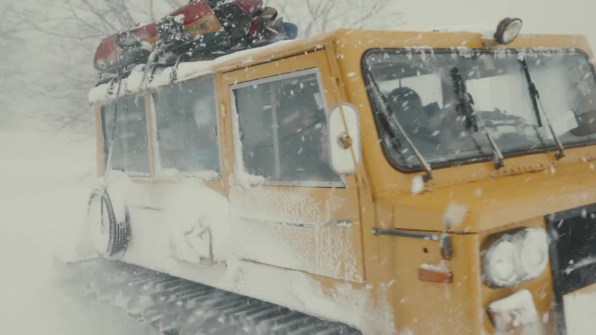 A special snow vehicle carrying a group of men through a heavy snowstorm