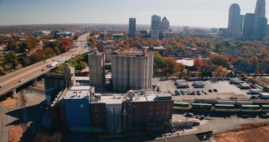 Aerial view of a viaduct with vehicle traffic a freight train and a metropolis with skyscrapers in the background