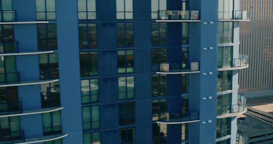 An aerial view showcases a dense urban landscape filled with tall modern buildings under a clear sky