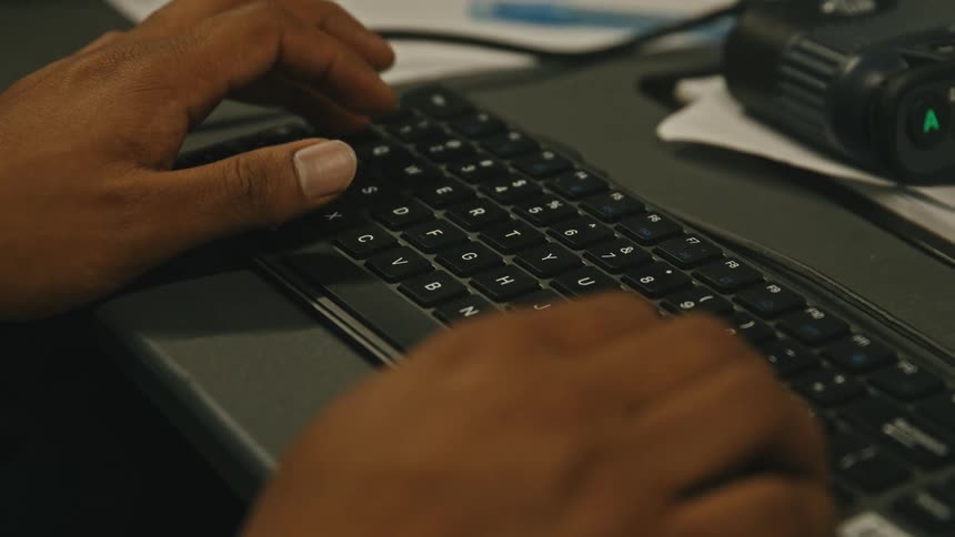A person typing on a computer keyboard