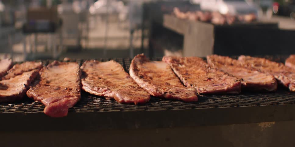 Steaks are cooking on the grill outside