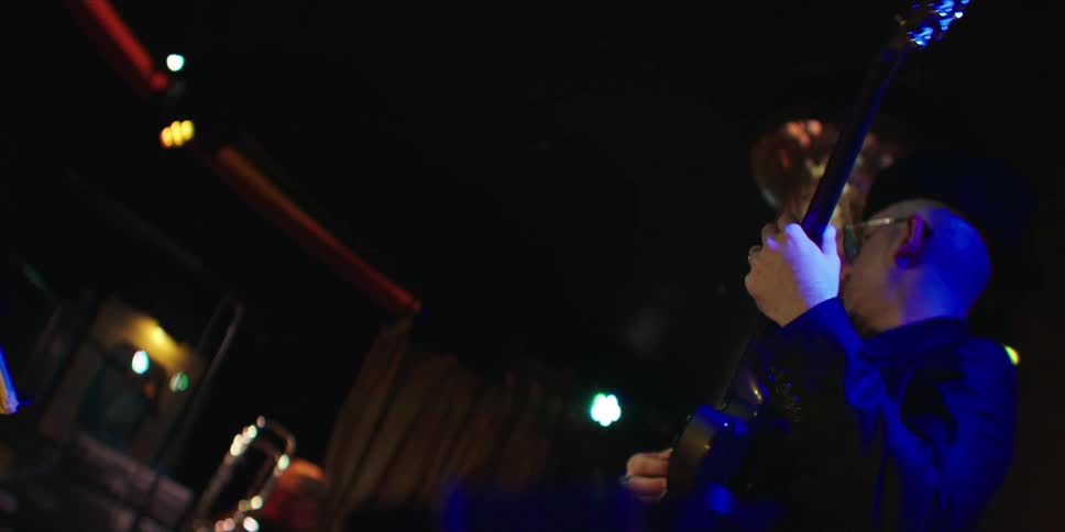 A man plays electric guitar on stage beside a keyboardist during a live music performance