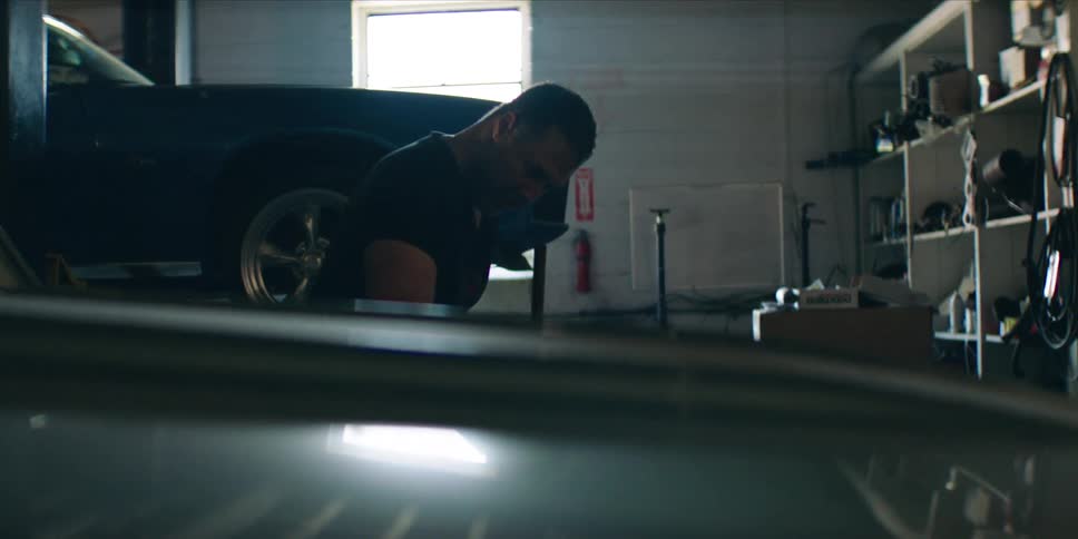 Male mechanic works in a car garage during the daytime