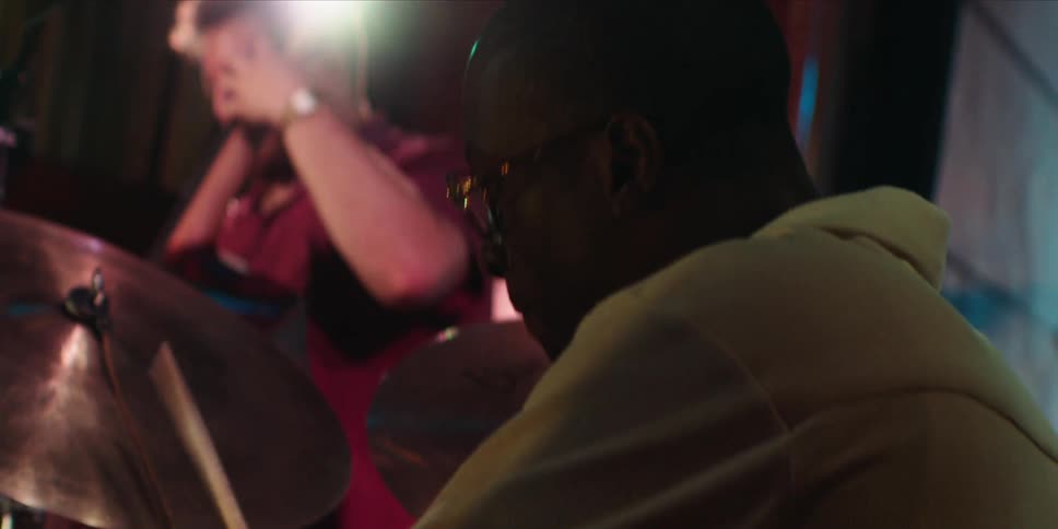 Two people are playing musical instruments indoors during a lively party event