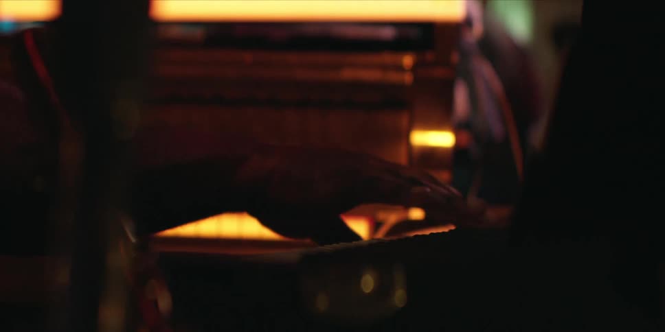 Hand playing piano in a low light environment
