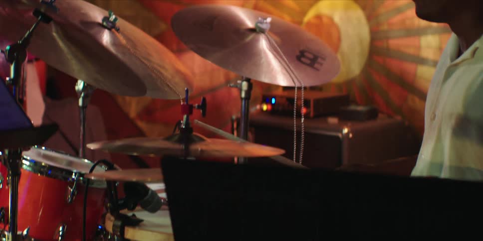 A man playing a drum passionately with great excitement and energy