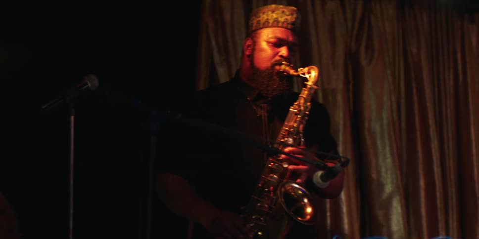 The man is playing the saxophone