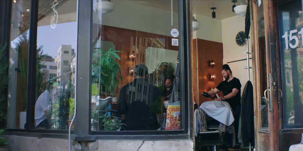 A barber is working with a customer in the barbershop