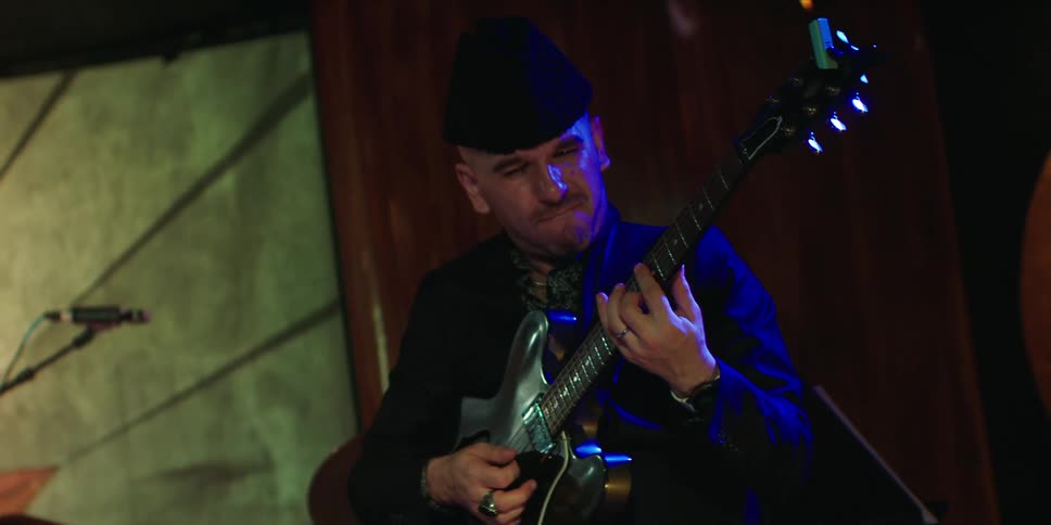 Male guitarist plays a guitar during a band performance