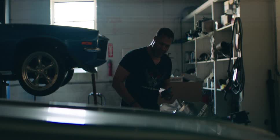 Car mechanic working in a commercial garage examines a car