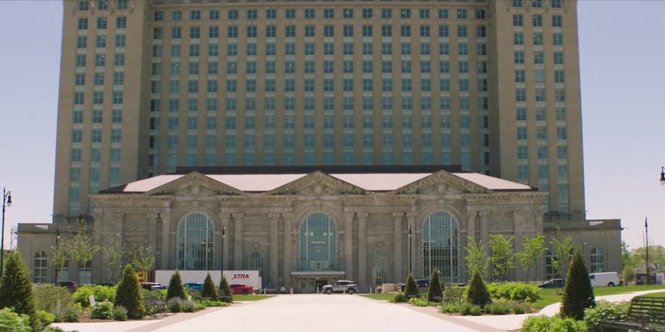 Historic building with classical design stands tall amid greenery in daylight