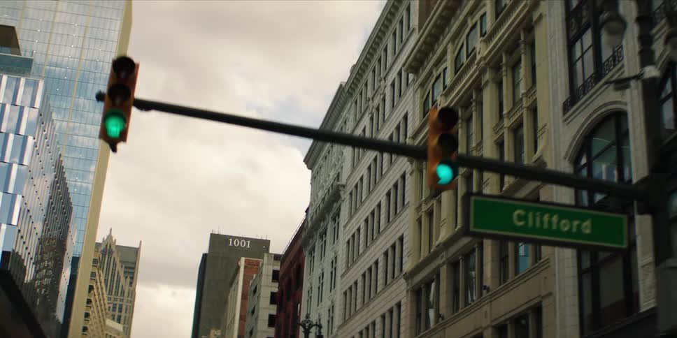 A city street view showing historic and modern buildings under a cloudy sky