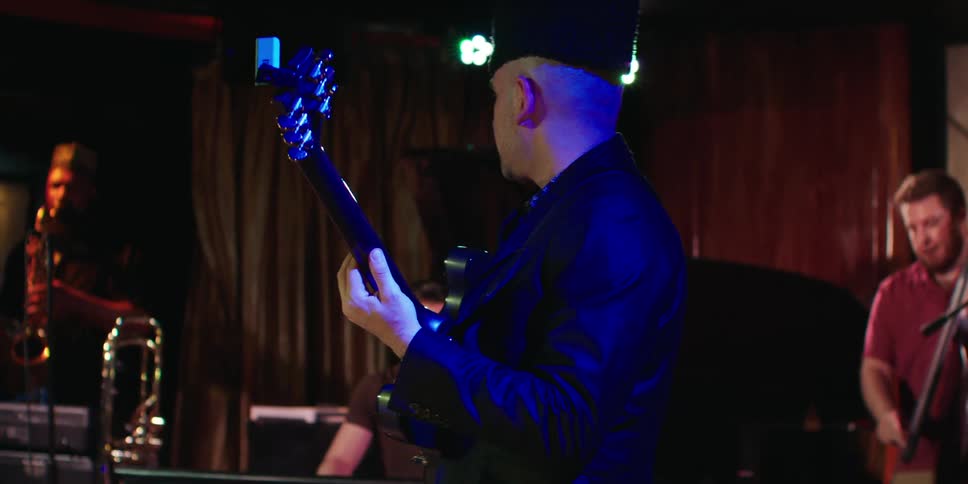 A group of musicians is playing instruments together indoors at an event