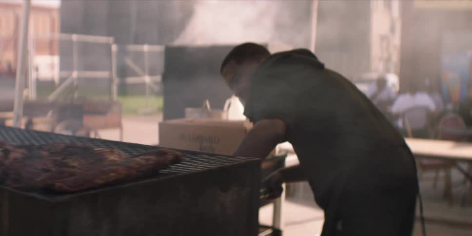 A man grills chicken at his small shop focused on preparing food for customers