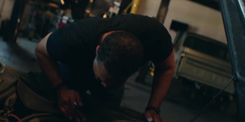 A man is repairing a car inside a garage