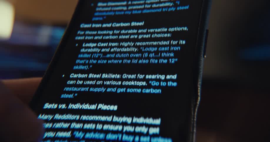 A hand scrolls through search results on a smartphone while googling something