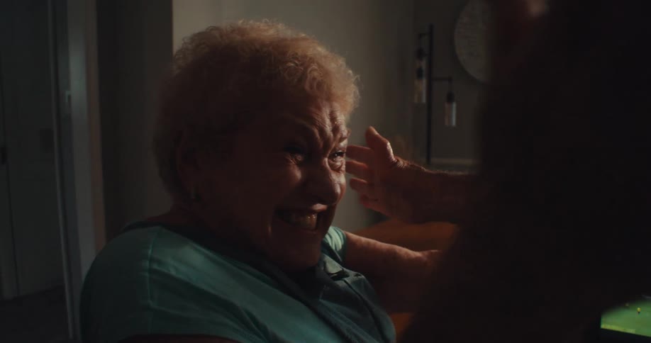 Two elderly couples watching a soccer game and celebrating a goal by hugging each other