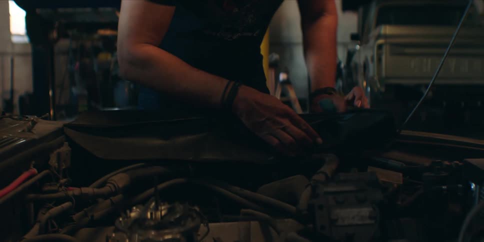 The man is fixing the engine in the auto shop