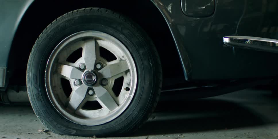 A car wheel with a partially flat tire on a concrete floor