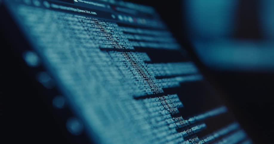 Text scrolls up the screen of a laptop indoors