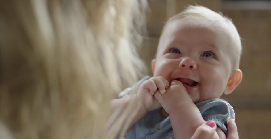A woman holds a smiling baby