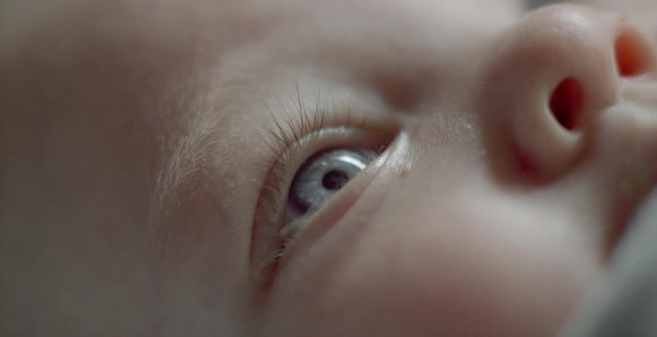 A baby lies with its eyes wide open