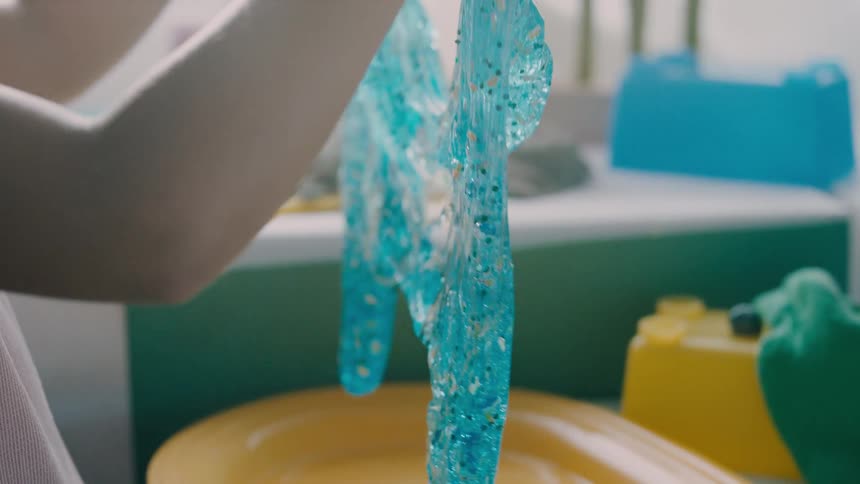 Child plays with blue slime while in a playroom during the day