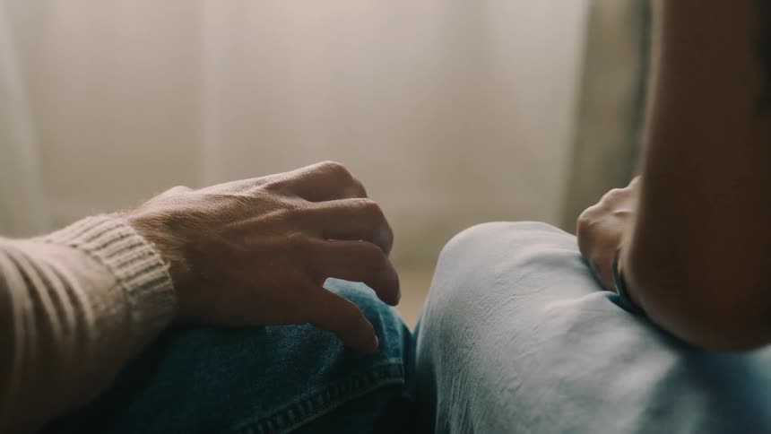 Close shot of a shy male hand reaching to hold a womans hand