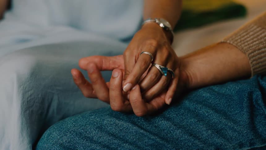A closeup shot of a couples hands gently holding each other with warmth and affection