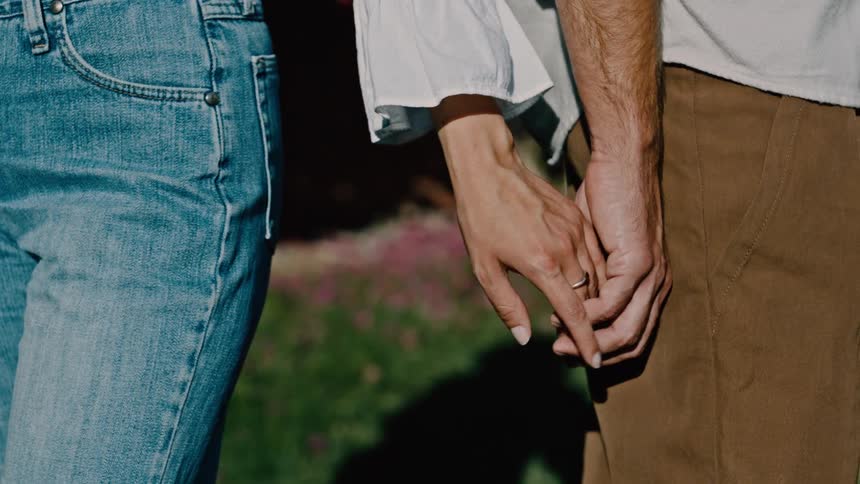 A man and woman briefly touch hands together