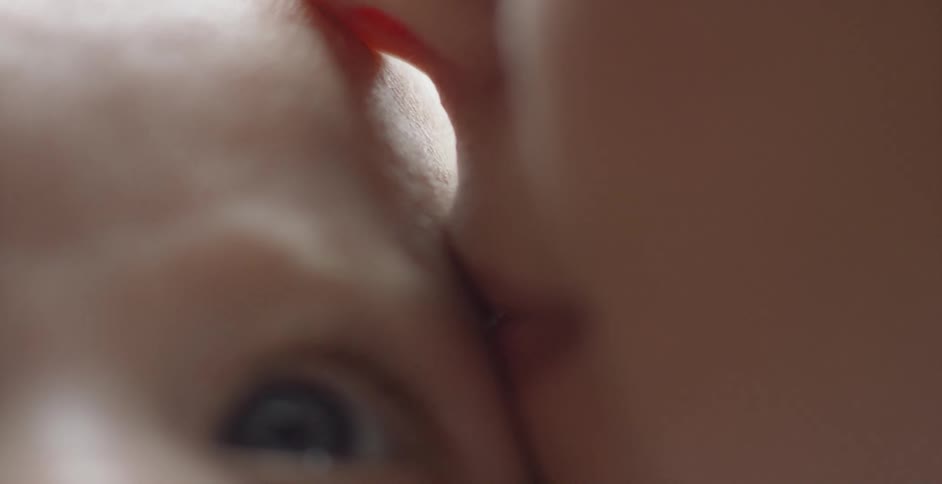 A woman kisses a baby's head