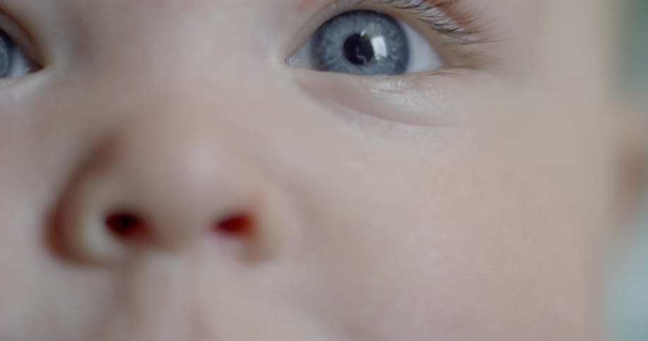 A blue-eyed baby blinks and looks around