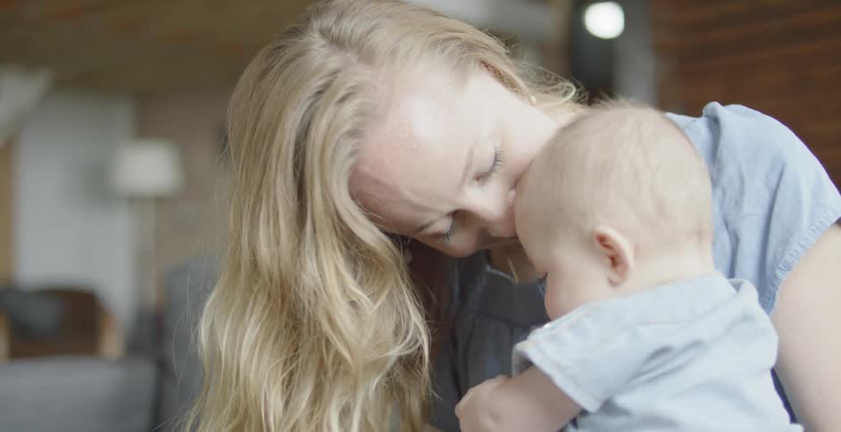 A woman plays with a baby on her lap