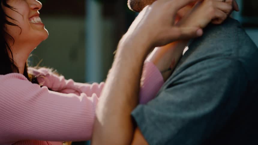A couple shares a tender moment while gently dancing together outdoors