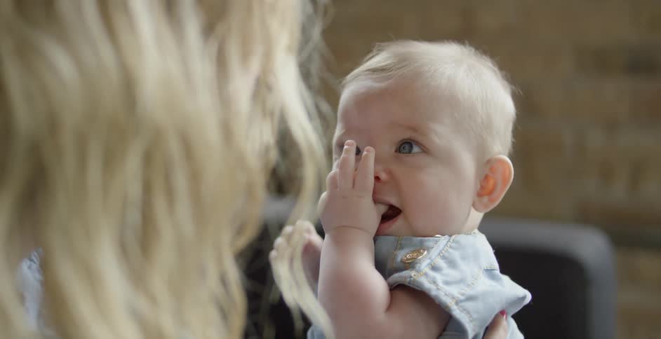 A woman looks at a baby in her lap