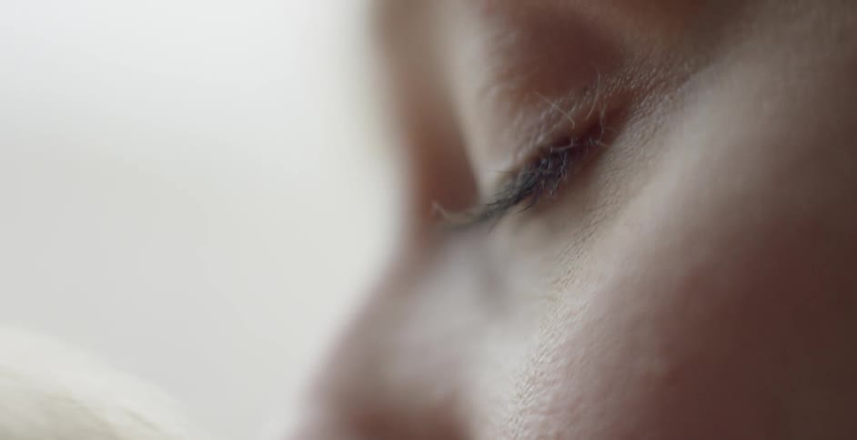 A woman turns and opens her eyes