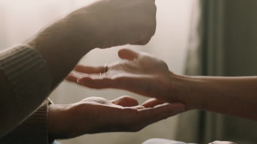 Man and woman move through the motions of the hand gestures involved in a complicated handshake