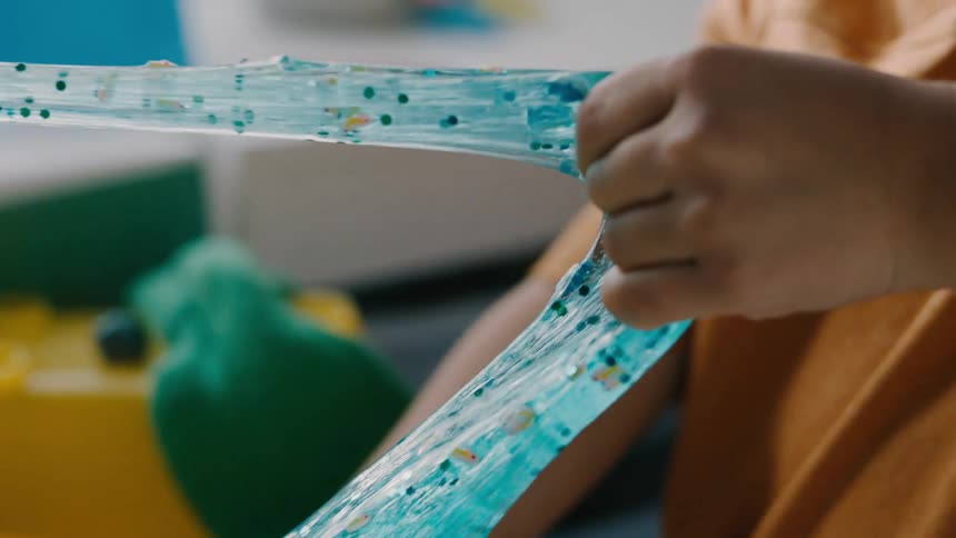A kid playing with a blue slime