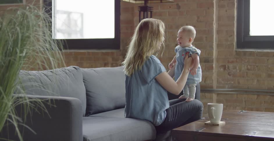 A woman holds a baby on her knees