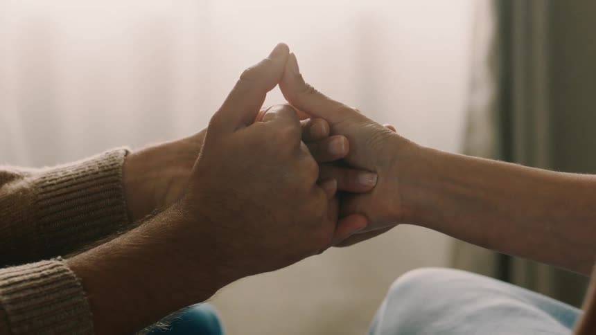 Closeup of two people holding hands in an affectionate moment