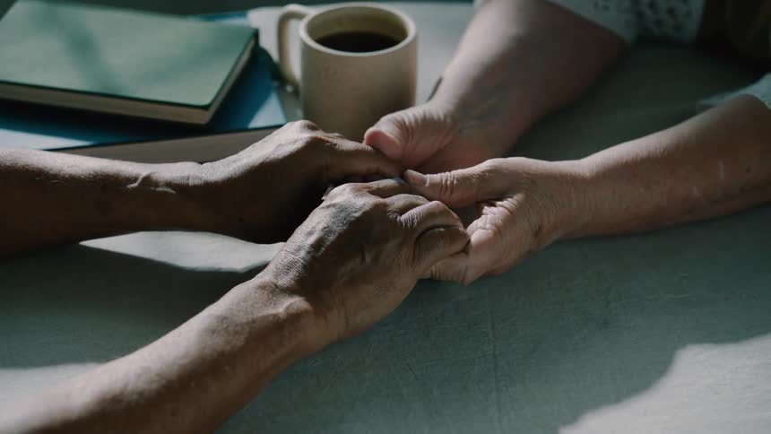 Two people are holding hands and rubbing them together