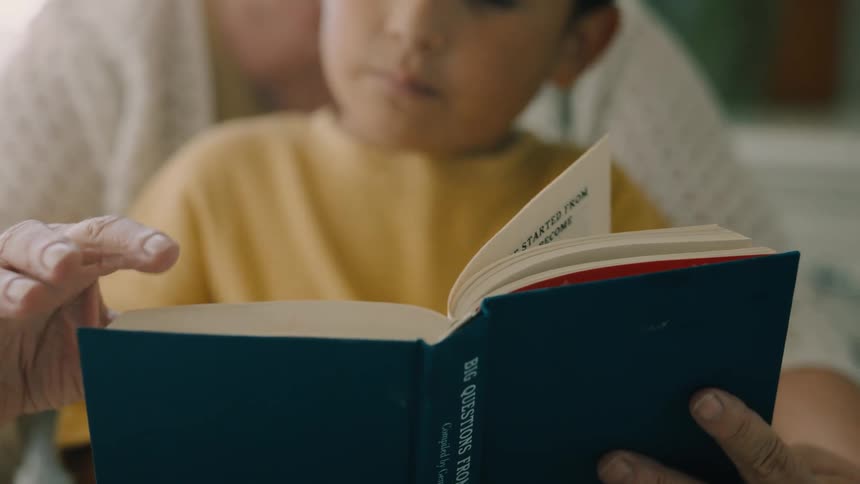 Grandma holding a book for her grandson to read