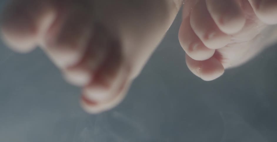 A baby's feet are shown underwater