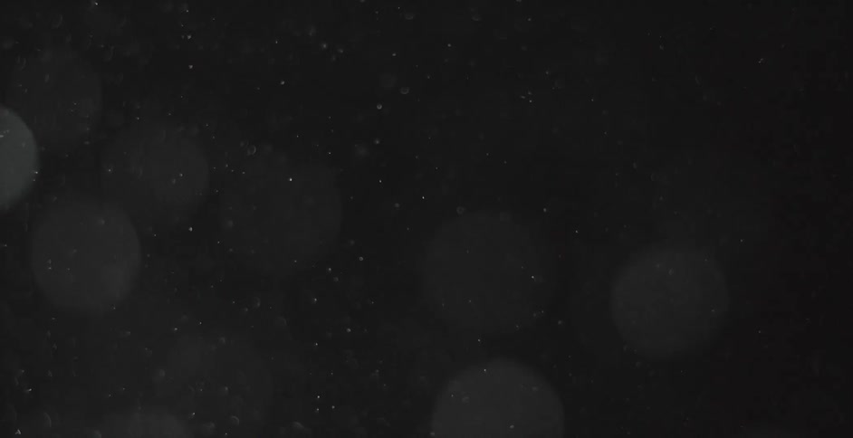 White particles floating in a dark room