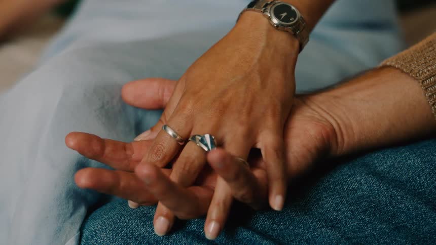 Close up of a couples hands as they caress and hold each others hands
